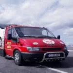 Autospecială roșie de tractări auto BID Remorcări pe autostradă în zona Turda